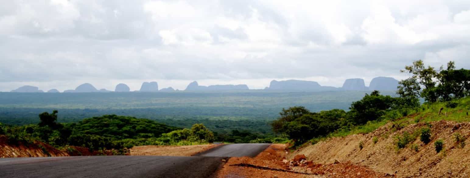 I baggrunden ses stenformationerne Pungo Andongo omringet af den flade savanne. Geologisk er formationerne forbundet med stor uvished