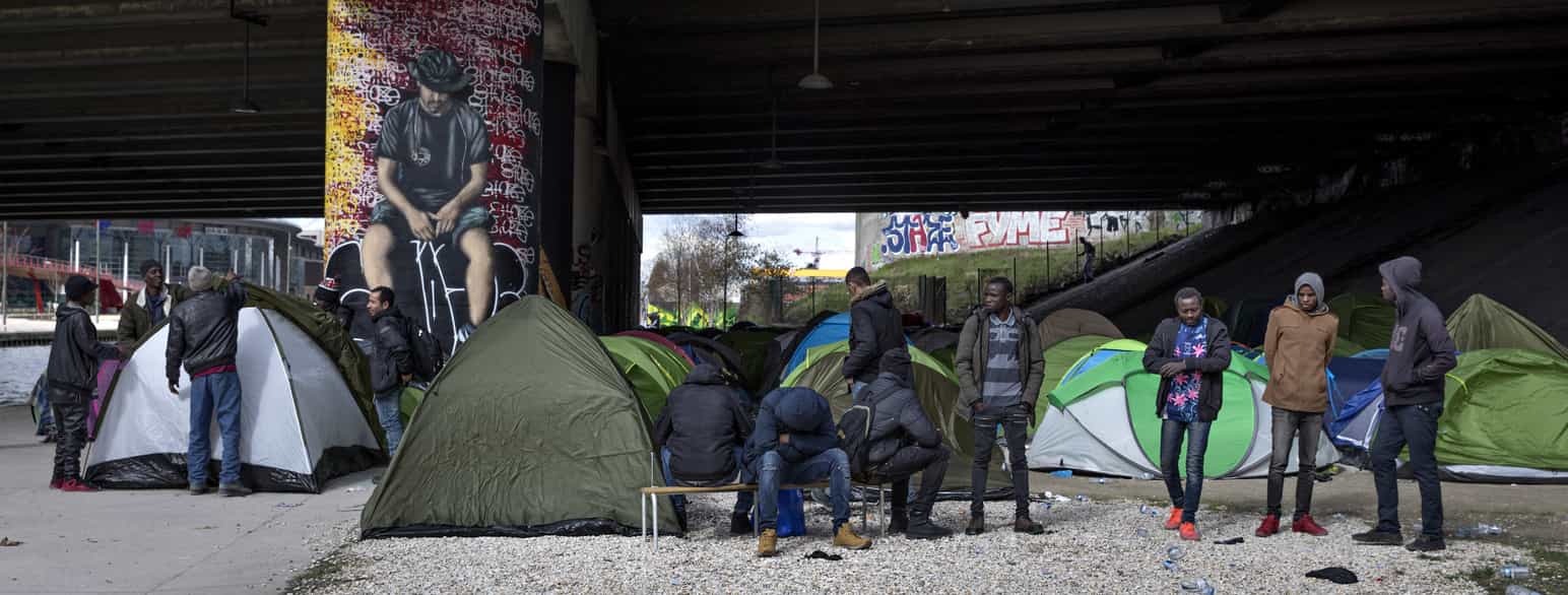 En gruppe flygtninge fra især Sudan og Eritrea har slået lejr under en motorvejsbro i Paris den 11. marts 2018.
