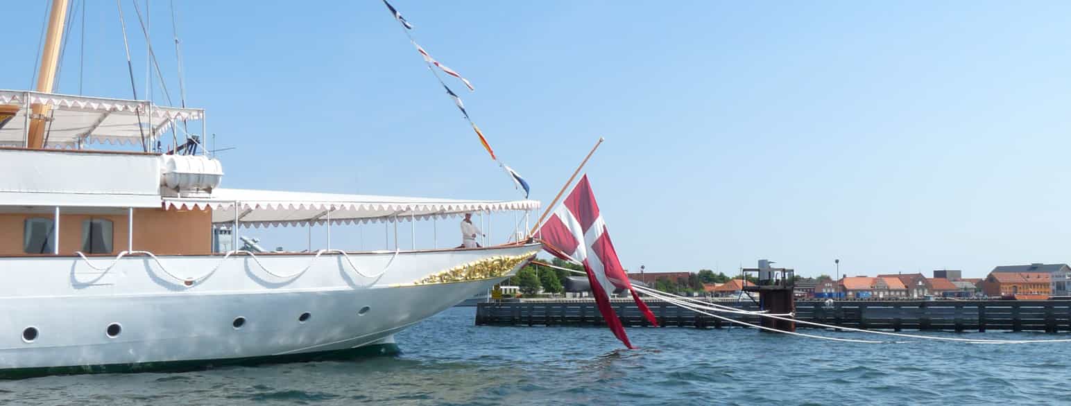 Kongeskibet Dannebrog kipper med flaget som hilsen til et mindre fiskefartøj i Københavns Havn juli 2011.