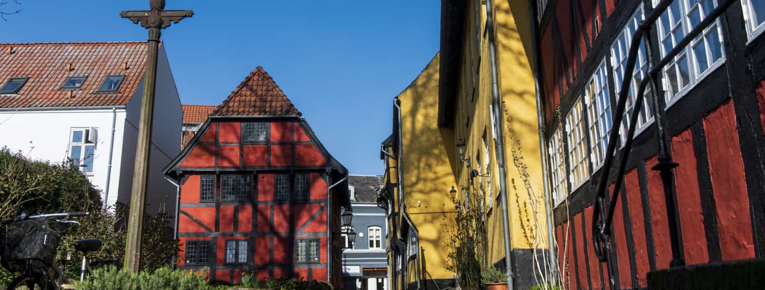 Det sort-røde bindingsværkshus til venstre er borgerhuset Helligkorsgade 18, som er byens ældste bygning fra 1589