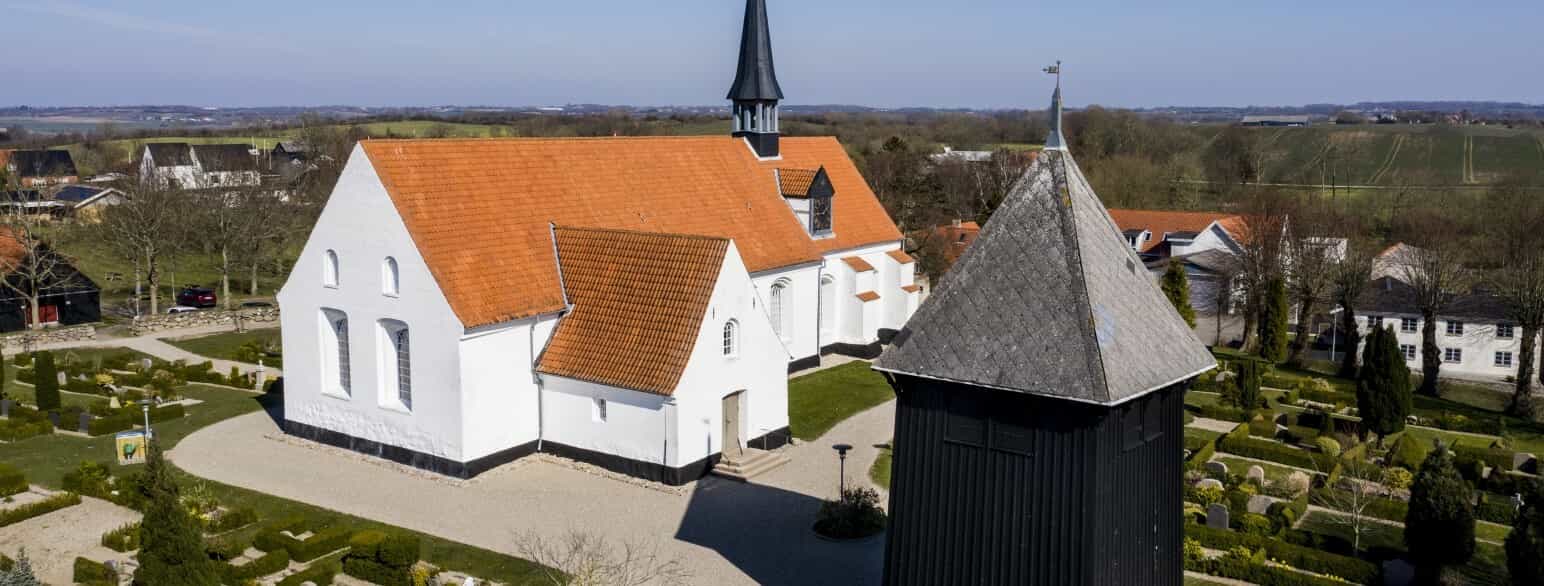 På kirkegården sydvest for Hørup Kirke står et af de tømrede klokkehuse, som Sønderjylland er berømt for