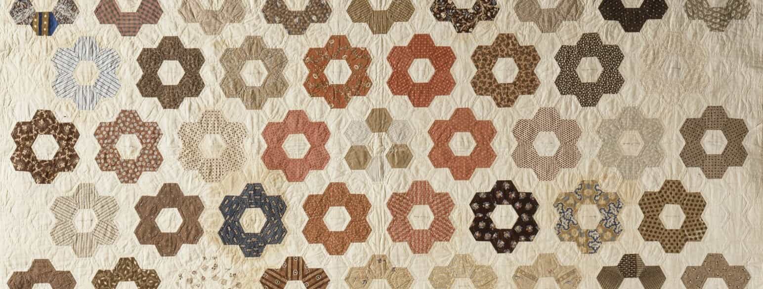 Udsnit af quiltet patchworktæppe af bomuld med motiv af sekskanter. Ca. 1865-1870.