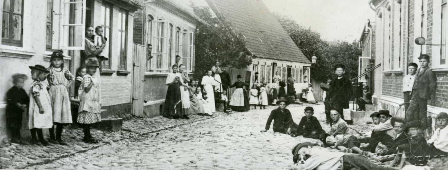 I Strandstræde i Marstal poserer børn og voksne for fotoografen i 1910'erne
