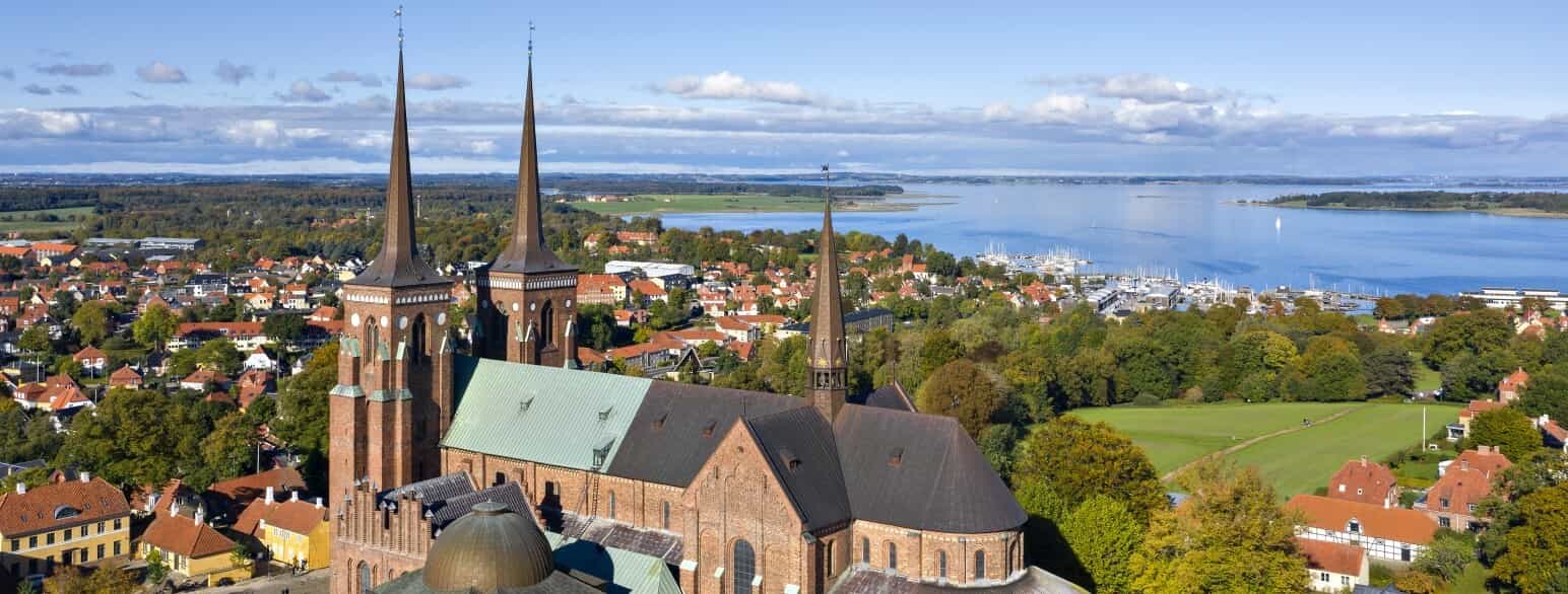Roskilde Domkirke med sine mange kapeller set fra sydøst og med fjorden i baggrunden