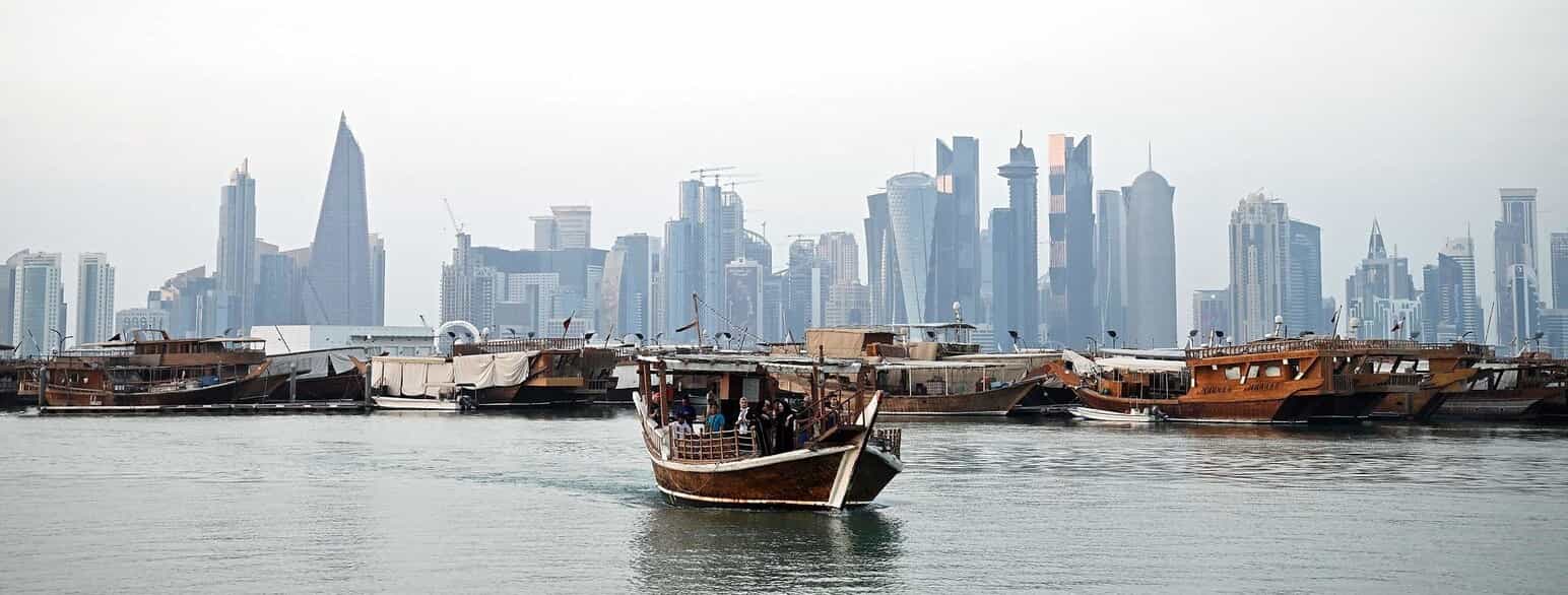 Dhow-både og Qatars hovedstad Dohas skyline i baggrunden.