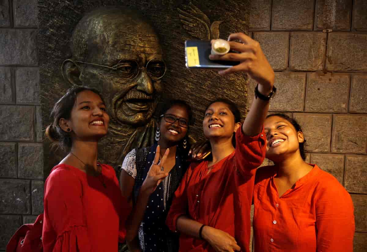 Studerende foran bronzestøbning af Gandhi