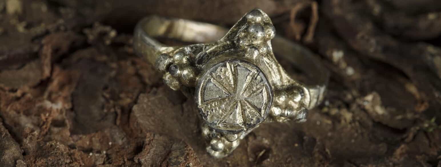 Fingerring fra Velbastaður af forgyldt sølv, dekoreret med de kristne symboler druer og kors.