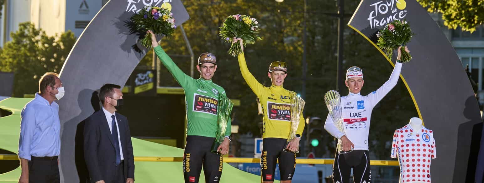 Wout van Aert i den grønne pointtrøje, ved siden af Jonas Vingegaard i den gule førertrøje og Tadej Pogacar i den hvide ungdomstrøje. Tour de France, 2022.