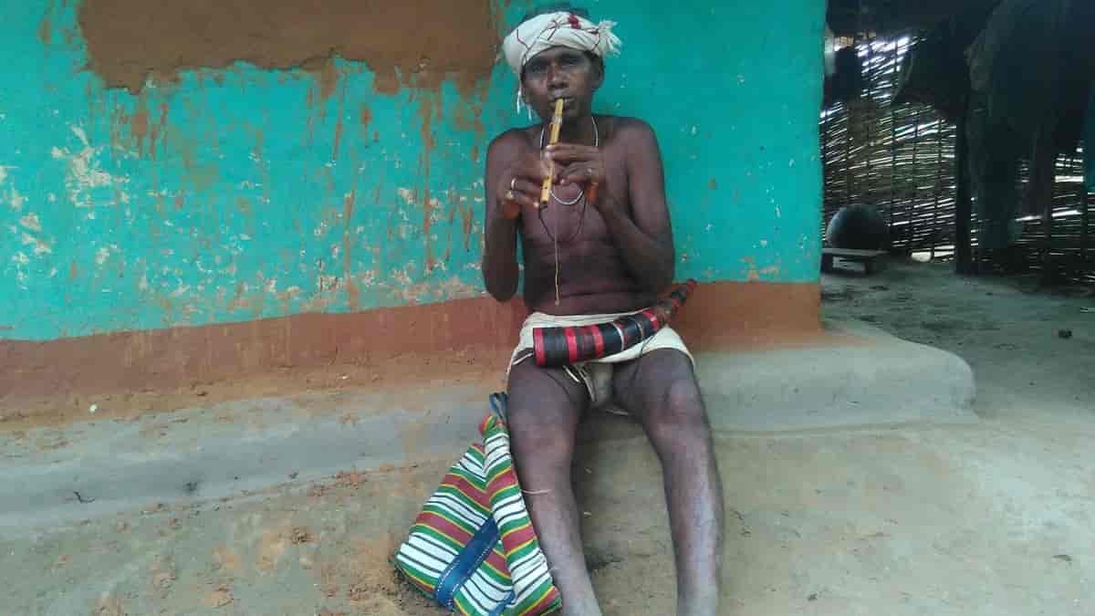 Ældre mand fra dhurwa-stammen demonstrerer fløjtespil.