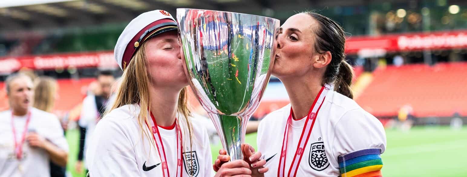Kvindepokalen får et kys af  Nikoline Dudek (t.v.) og Jessica Davis fra FC Nordsjælland efter sejren over  Fortuna Hjørring i 2023.