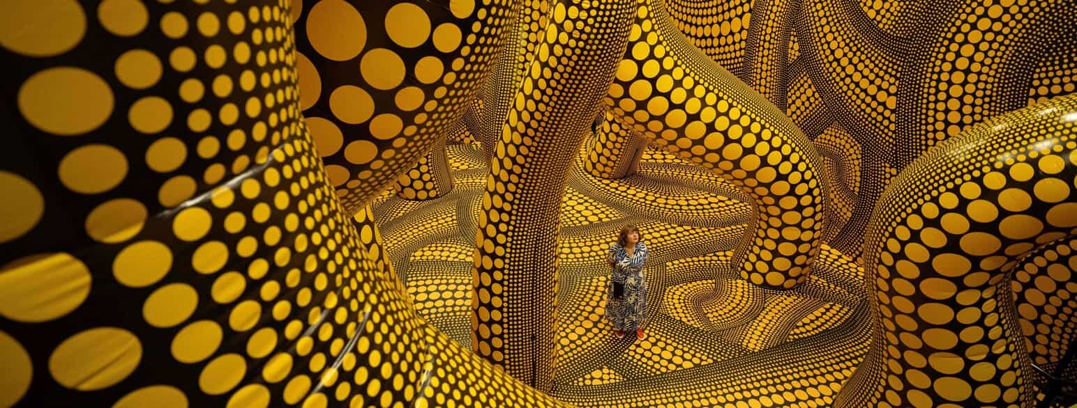 Museumsgæsten træder ind i værket 'The Hope of the Polka Dots Buried in Infinity Will Eternally Cover the Universe' af den japanske kunstner Yayoi Kusama 