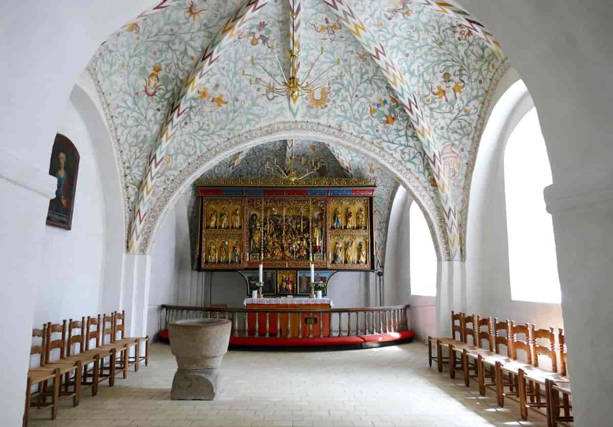 Billede inde i Løjt Kirke af kor, altertavle og kalkmalerier