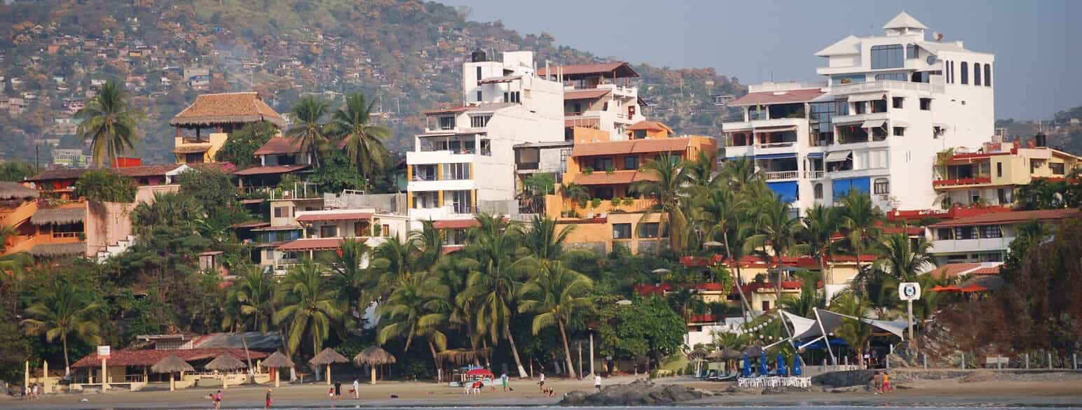 Hoteller, palmer og badeliv ved Playa Madera i Zihuatanejo på Guerreros Stillehavskyst