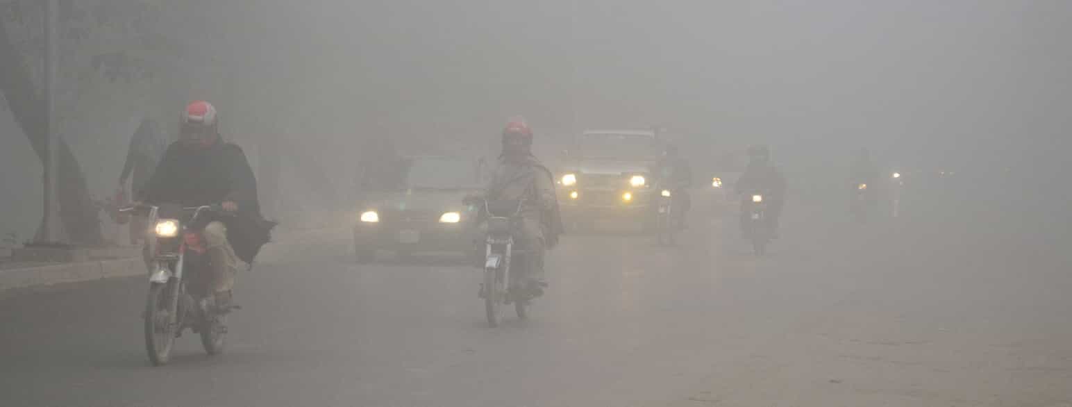 Motorcykler og biler kører gennem den tætte smog, der ramte byen Lahore i det østlige Pakistan i november 2017