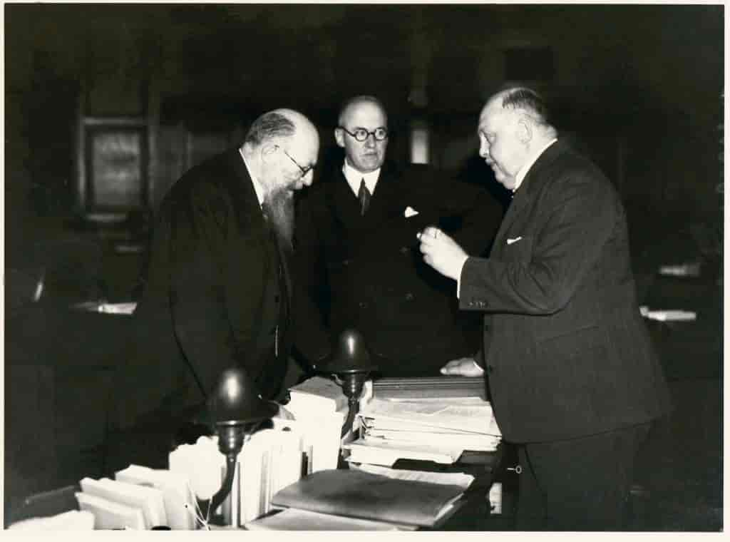 Foto, der viser Stauning, Steincke og Krag stående omkring et bord