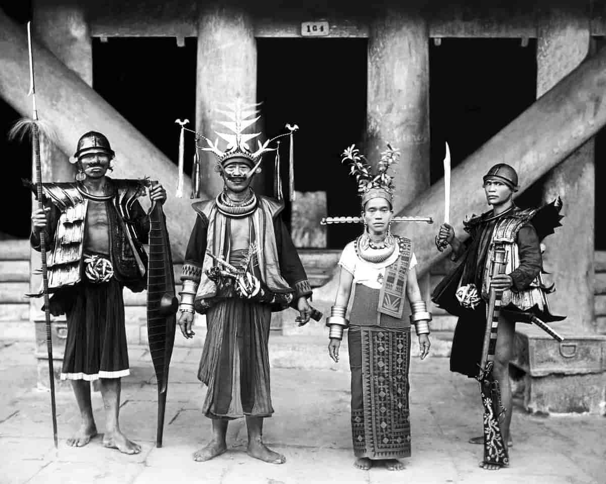 Høvdingen og hans hustru i landsbyen Bawamatawö flankeret af to krigere.