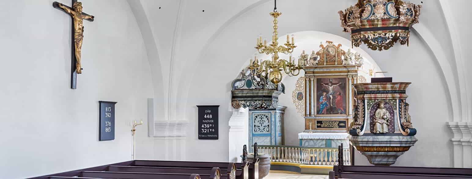 Bredsten Kirke. Korbuekrucifikset er fra o. 1520, mens altertavlen, prædikestolen og himlen over døbefonten er fra 1700-tallet