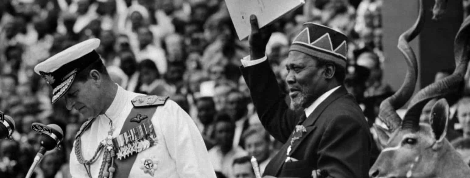 Jomo Kenyatta i 1963, hvor han blev indsat som præsident. I hånden løfter han Kenyas uafhængighedserklæring. På billedet ses også prins Philip, repræsentant for Storbritanniens dronning Elisabeth.