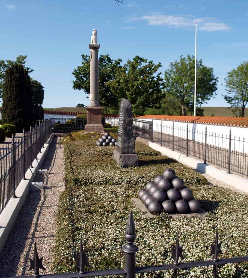 Monument med gravsten og kanonkugler