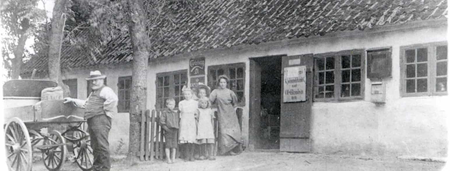 Købmanden Niels Jensen og hans familie foran købmandsbutikken, 1896