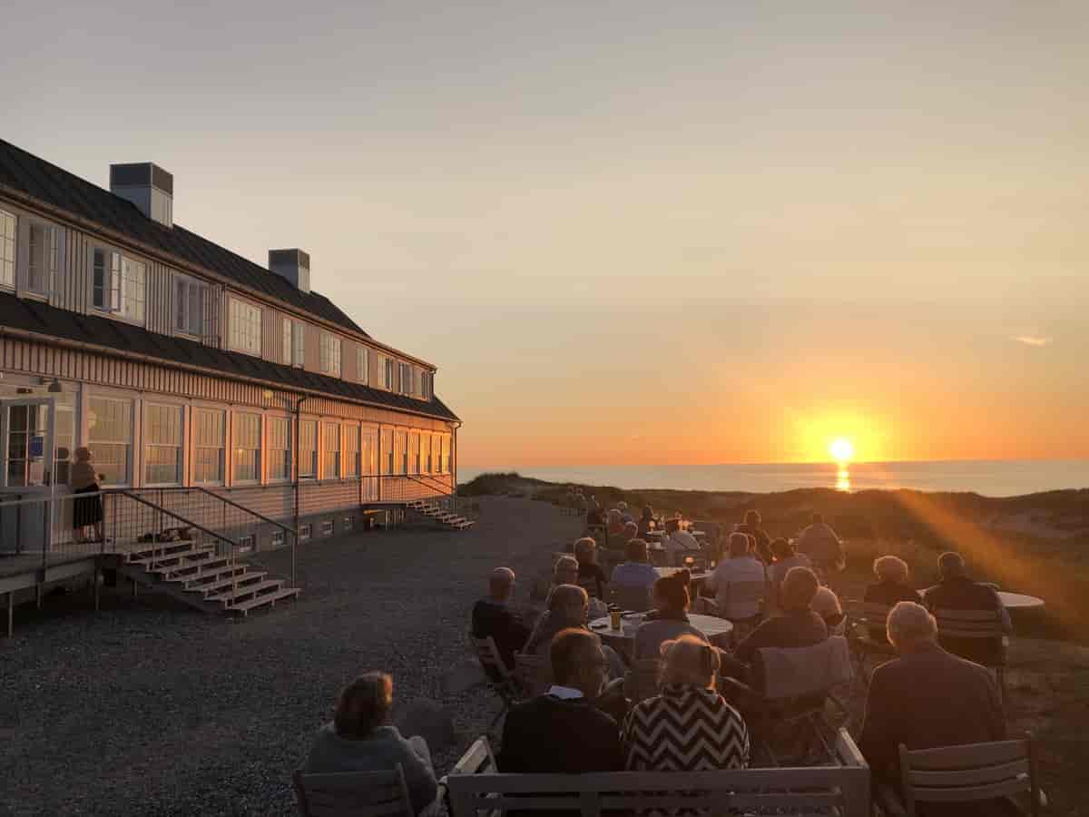 Gæsterne sidder på nordsiden af hotellet, mod stranden, og venter på solnedgang